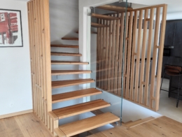escalier suspendu en chêne rustique avec marches fixées dans claustra bois et paroi verre