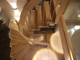 escalier suspendu marches en frêne profilées et main courante débillardé avec balustres courbés